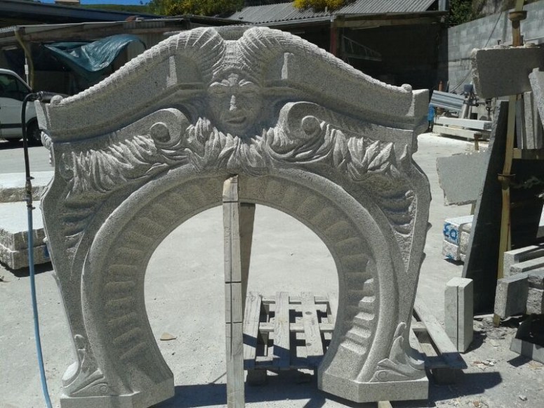 Chimenea de piedra, con fauno como figura central.